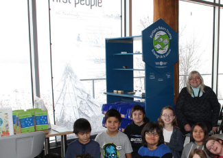 children and an adult gather around a learning centre